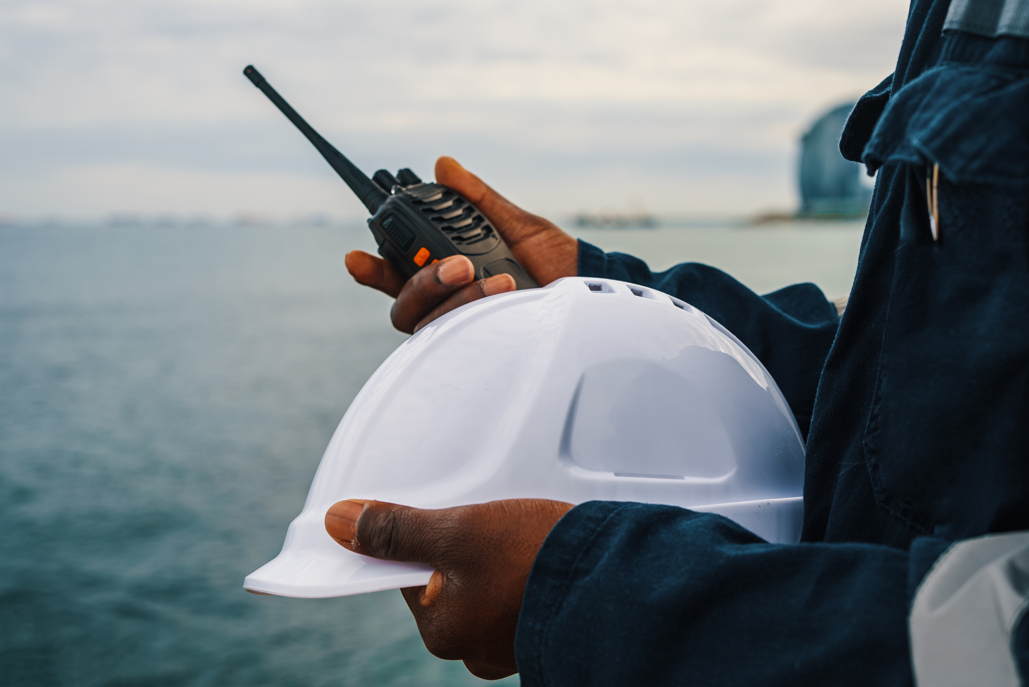 Hands of seaman with helmet and VHF radio